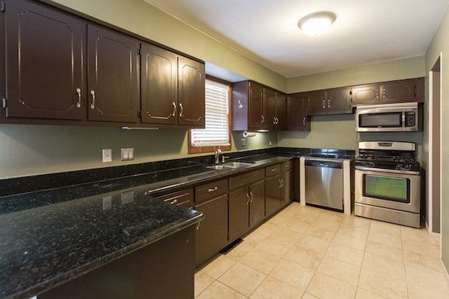 721 South Cooper Road New Lenox, IL 60451 - Photo 3 of 10 a large kitchen with stainless steel appliances granite countertop a stove a sink and a microwave