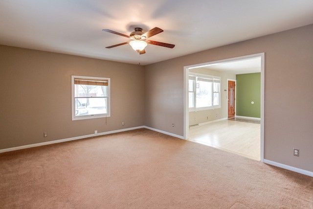 721 South Cooper Road New Lenox, IL 60451 - Photo 5 of 10 an empty room with chandelier fan and windows