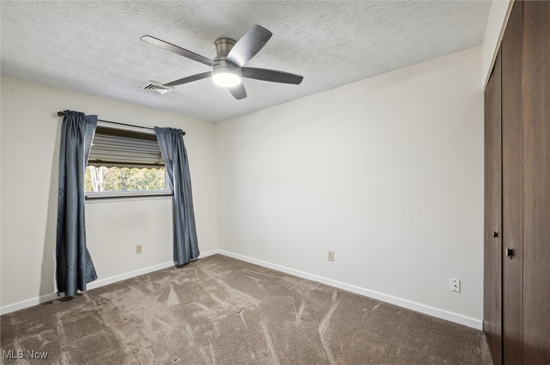 5476 Lear Nagle Road North Ridgeville, OH 44039 - Photo 17 of 38 Carpeted empty room featuring visible vents, baseboards, and ceiling fan