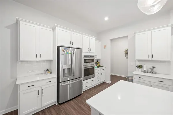 a kitchen with white cabinets and stainless steel appliances