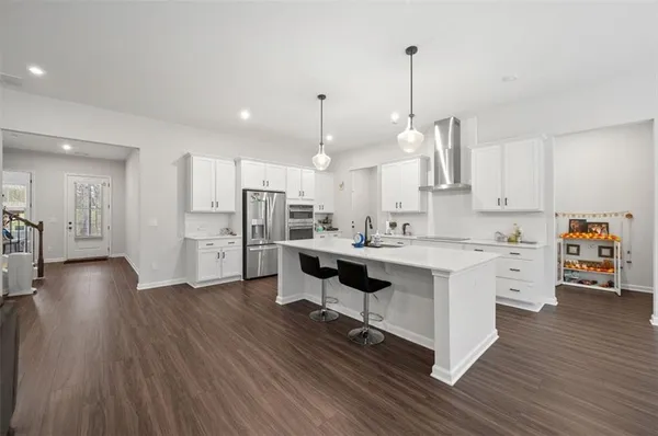 a kitchen with stainless steel appliances kitchen island hardwood floor sink and stove