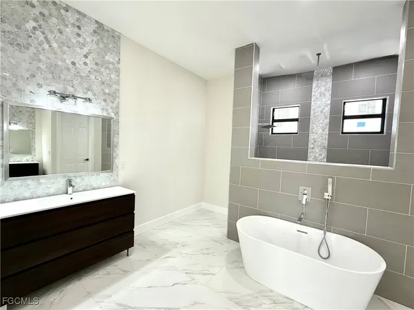 a bathroom with a bathtub sink and mirror