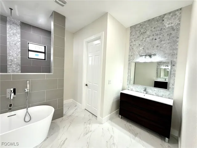 a bathroom with a tub sink and mirror
