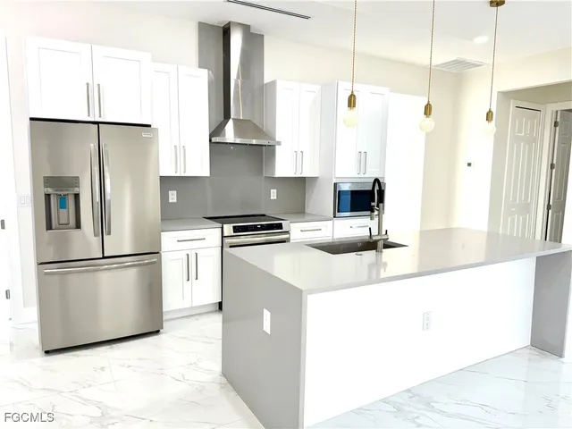 a kitchen with stainless steel appliances a refrigerator and a sink