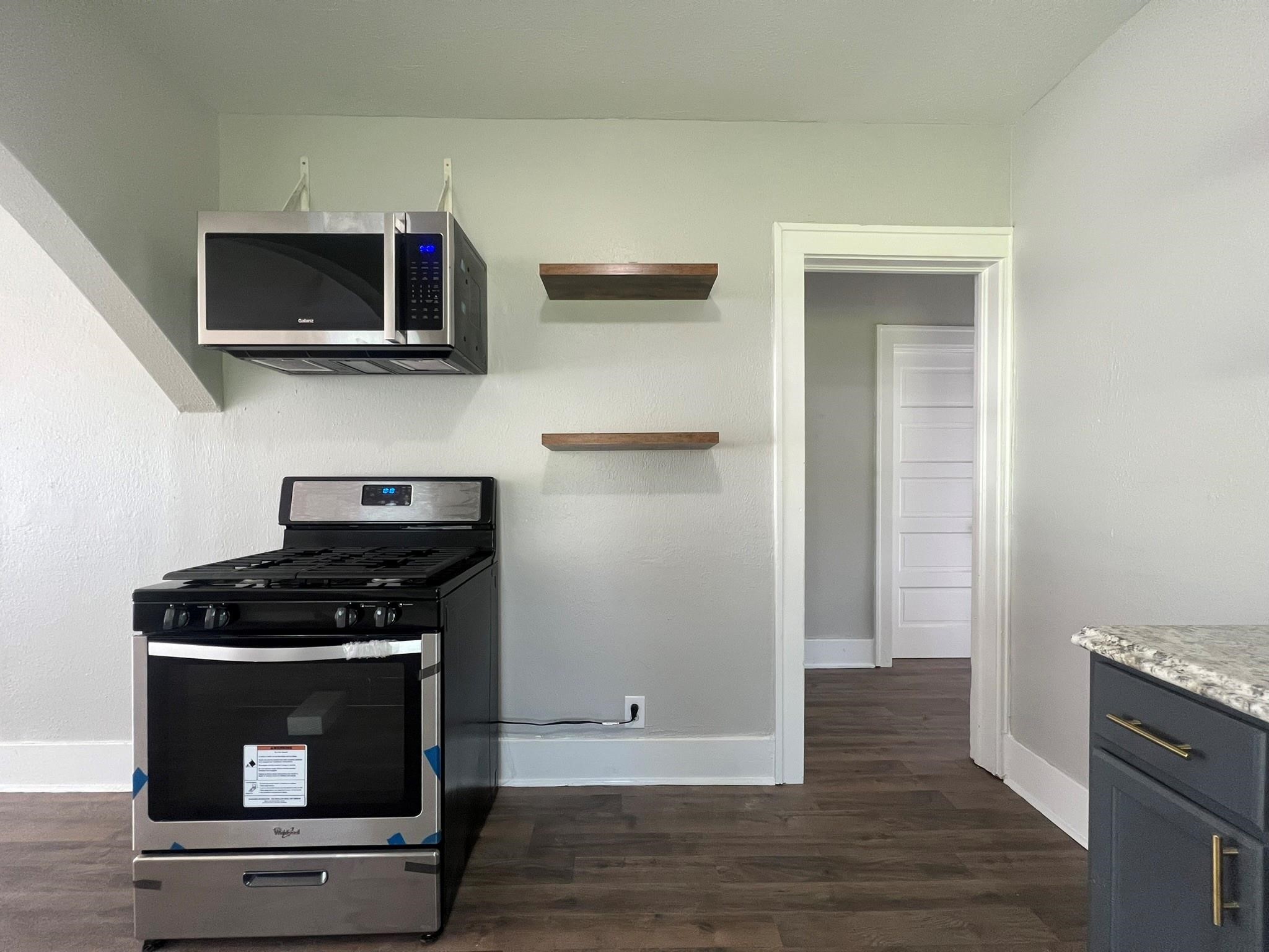 2531 Stevens Street Houston, TX 77026 - Photo 12 of 39 a kitchen with stainless steel appliances wooden cabinets and a stove top oven
