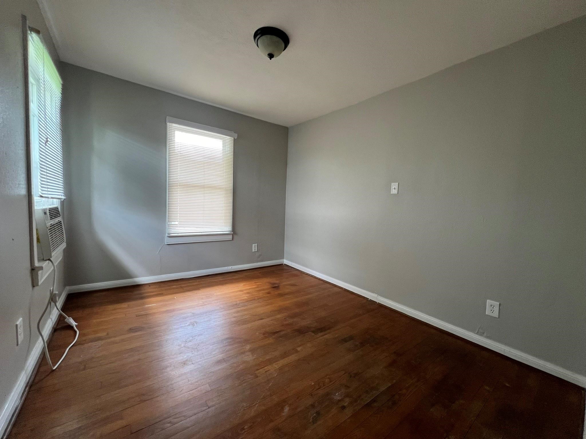 2531 Stevens Street Houston, TX 77026 - Photo 33 of 39 an empty room with wooden floor and windows