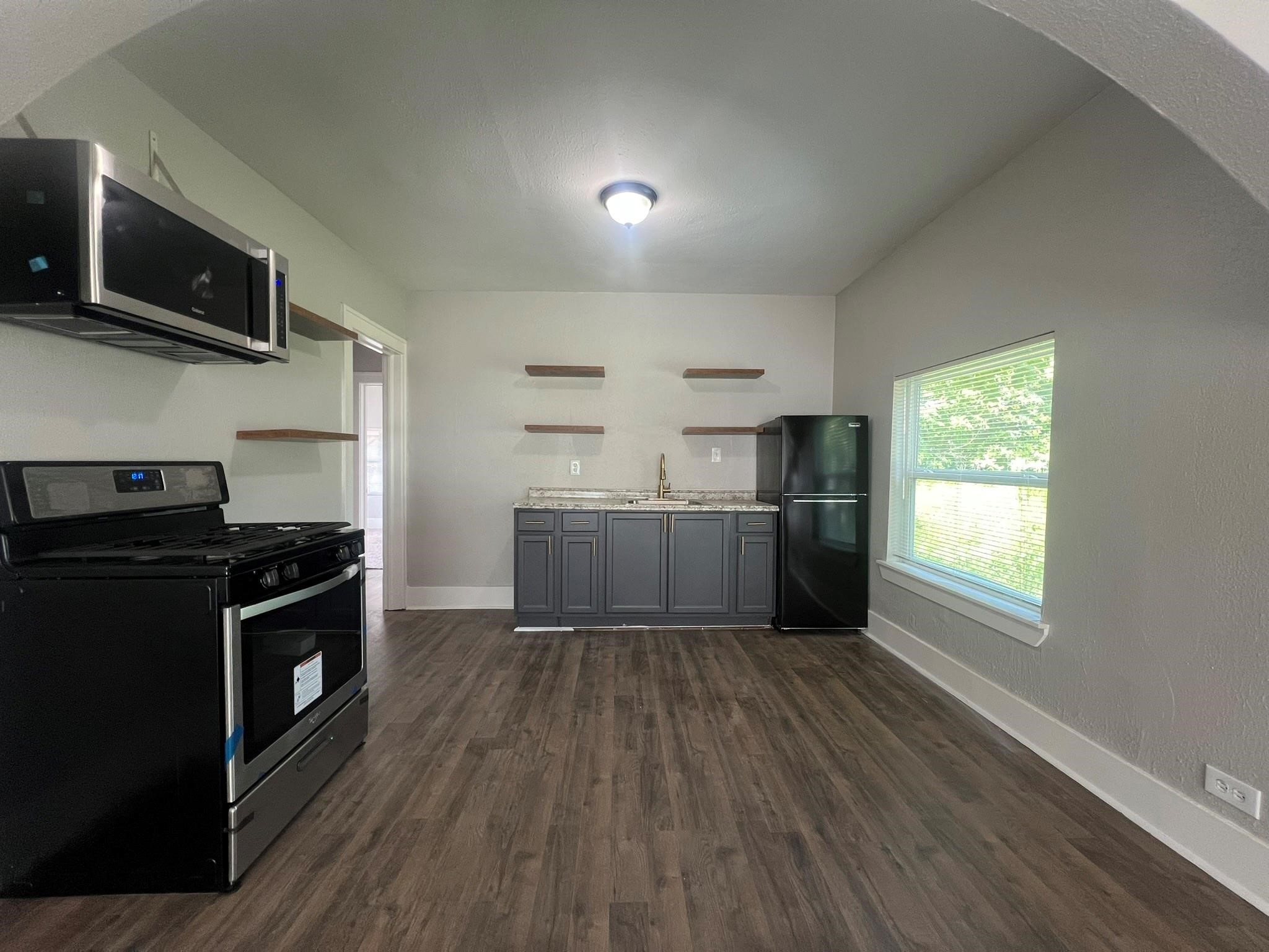 2531 Stevens Street Houston, TX 77026 - Photo 9 of 39 a kitchen with wooden floors and stainless steel appliances