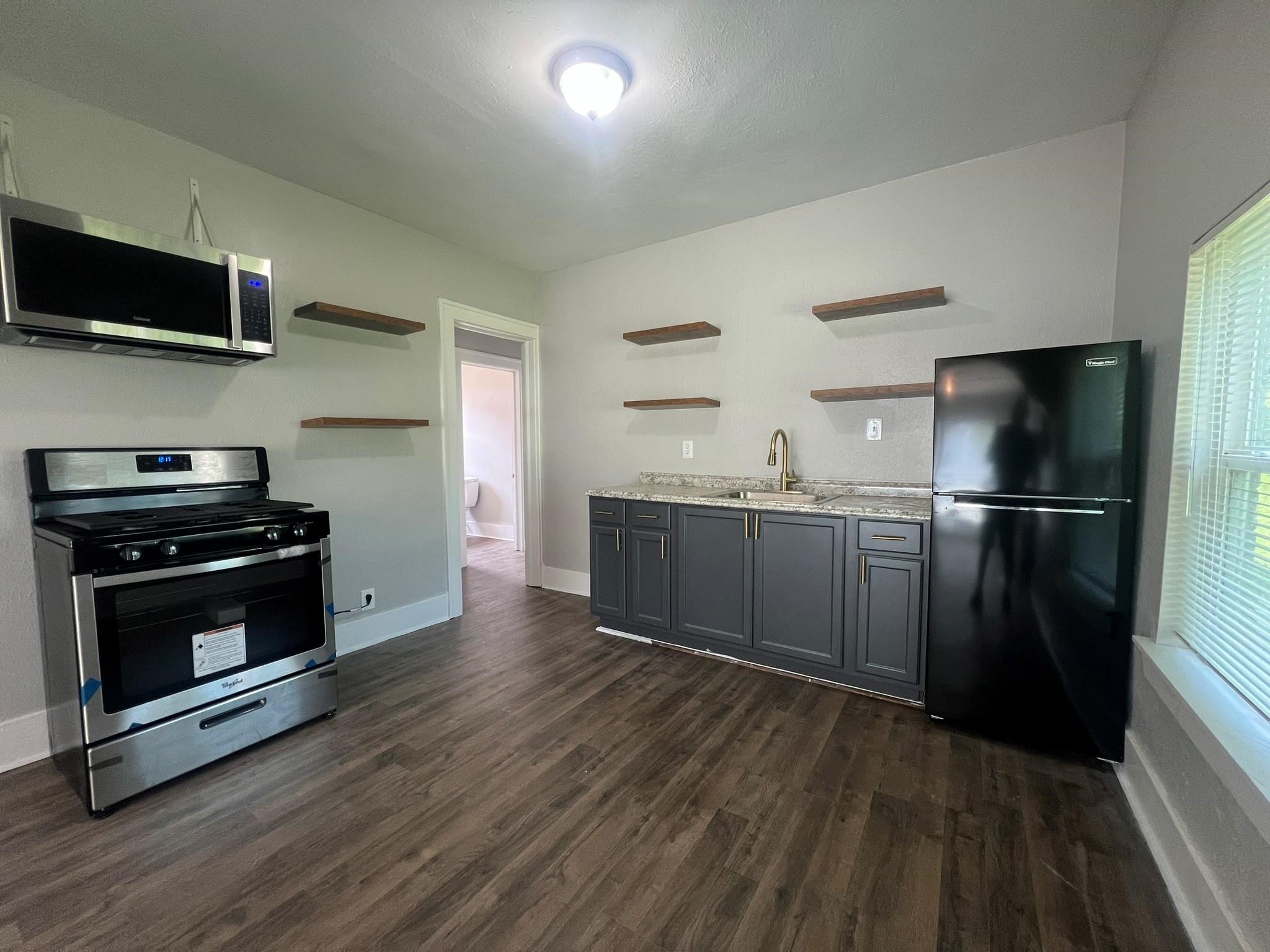 2531 Stevens Street Houston, TX 77026 - Photo 10 of 39 a kitchen with stainless steel appliances wooden floor sink and wooden cabinets