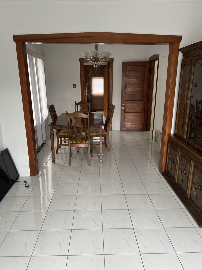 7416 West Addison Street Chicago, IL 60634 - Photo 2 of 19 a dining room with furniture and a flat screen tv