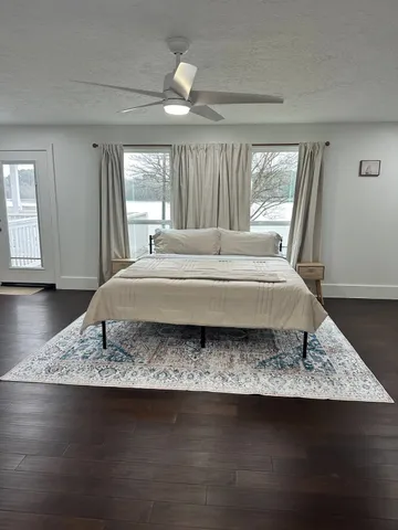 a spacious bedroom with a bed rug and window