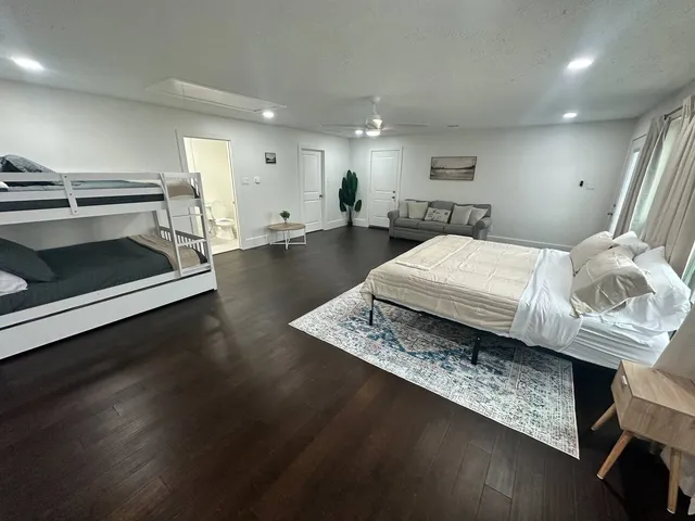 a living room with a bed furniture and a wooden floor