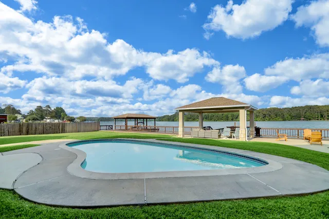 a view of a white house with a big yard and potted plants