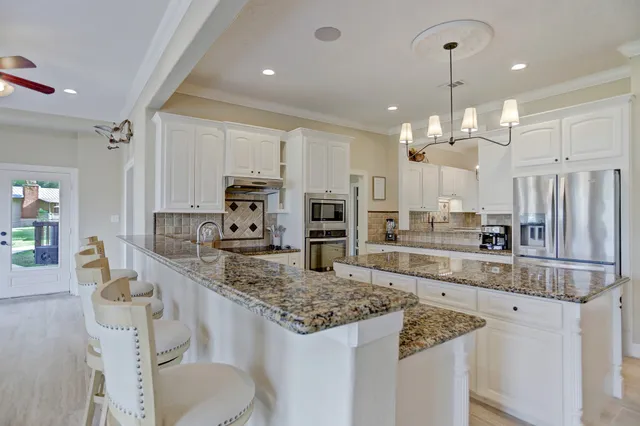 a large kitchen with kitchen island a large center island and stainless steel appliances
