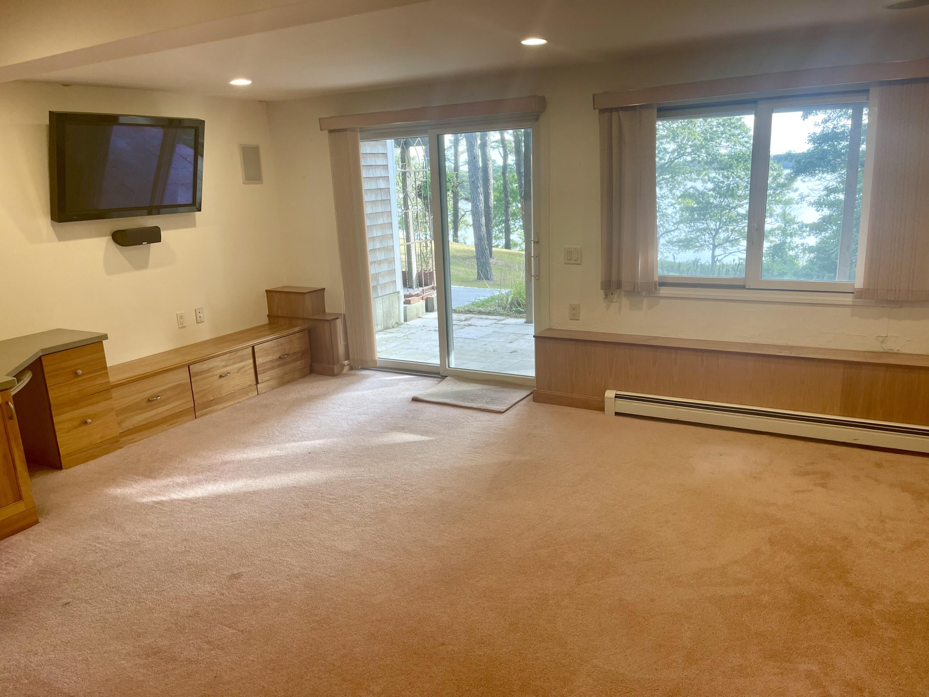 1 Calico Circle, Unit 1 Dennis, MA 02639 - Photo 27 of 52 a view of a livingroom with furniture a flat screen tv and floor to ceiling window