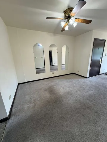 a view of a livingroom with a ceiling fan and wooden floor
