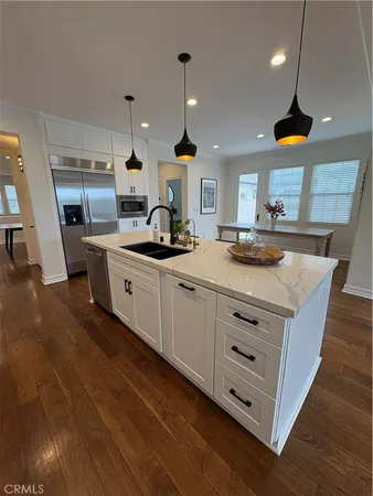 a kitchen with stainless steel appliances granite countertop a sink a stove and a wooden floors