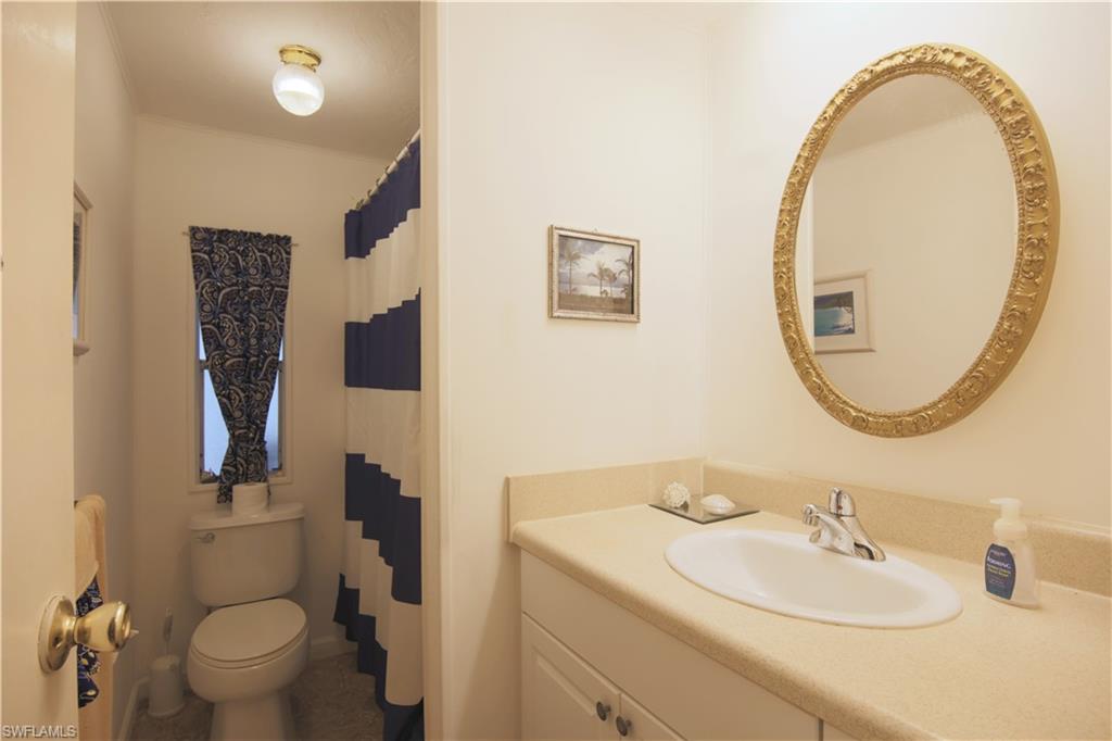 883 Manatee Road Naples, FL 34114 - Photo 13 of 15 a bathroom with a sink and a mirror