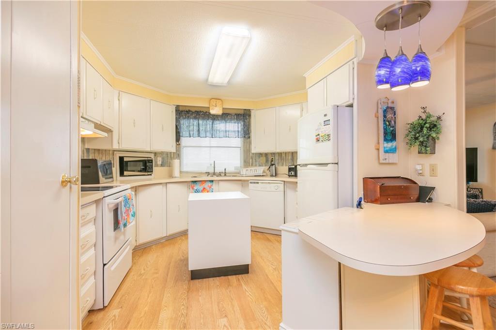 883 Manatee Road Naples, FL 34114 - Photo 9 of 15 a kitchen with a sink a kitchen island and stainless steel appliances