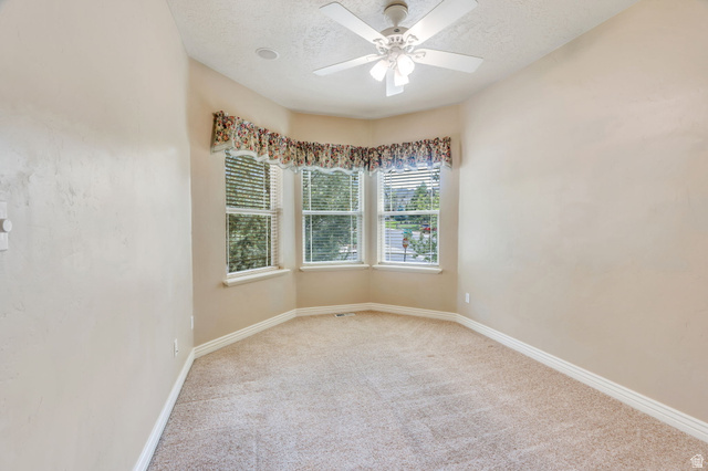 373 East Alexander Drive Elk Ridge, UT 84651 - Photo 15 of 69 Bay window with blinds, ceiling fan, neutral carpet, and light-colored walls