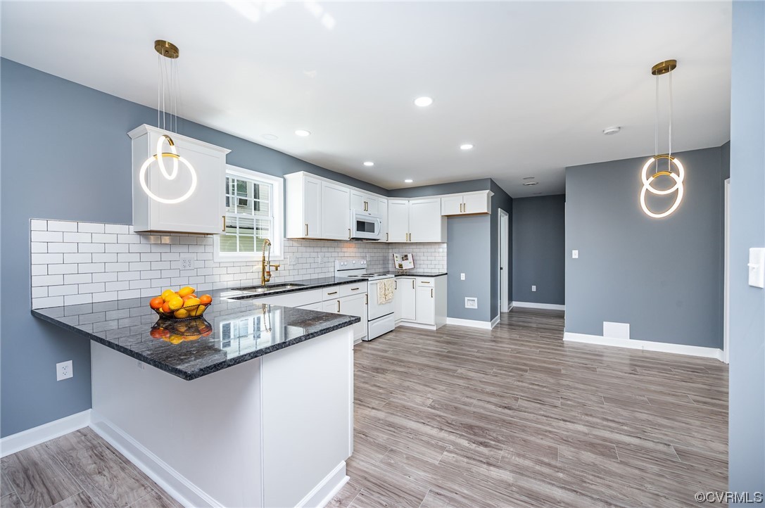 706 Rome Street Petersburg, VA 23803 - Photo 7 of 26 a kitchen with stainless steel appliances granite countertop a sink a stove and wooden floor