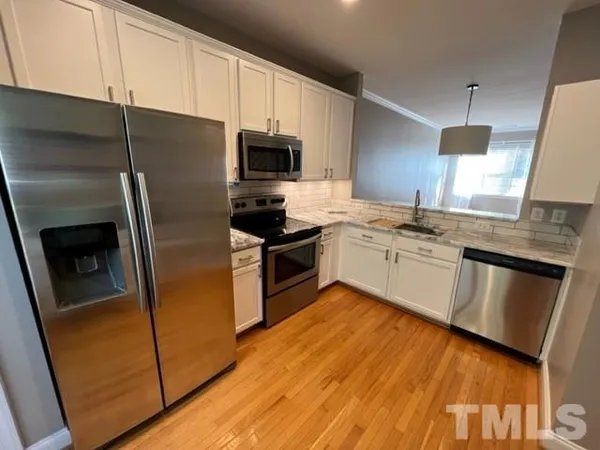 a kitchen with a sink a microwave a stove and refrigerator