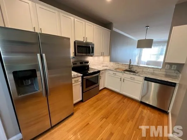 a kitchen with a sink a microwave a stove and refrigerator