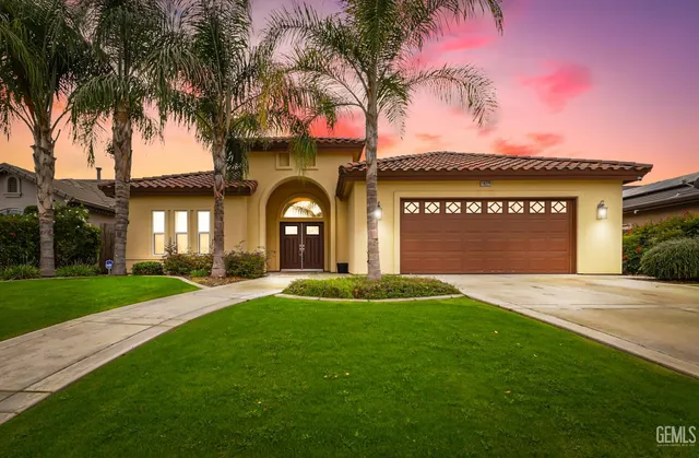 a front view of a house with a garden and a yard