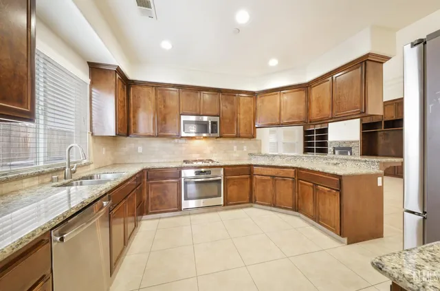 a kitchen with stainless steel appliances granite countertop a sink stove and cabinets