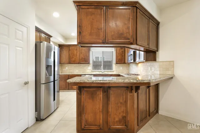 a kitchen with stainless steel appliances granite countertop a stove and a refrigerator