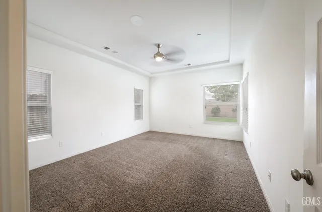 an empty room with windows and cabinet