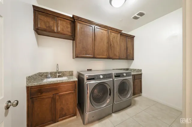 a utility room with sink dryer and washer
