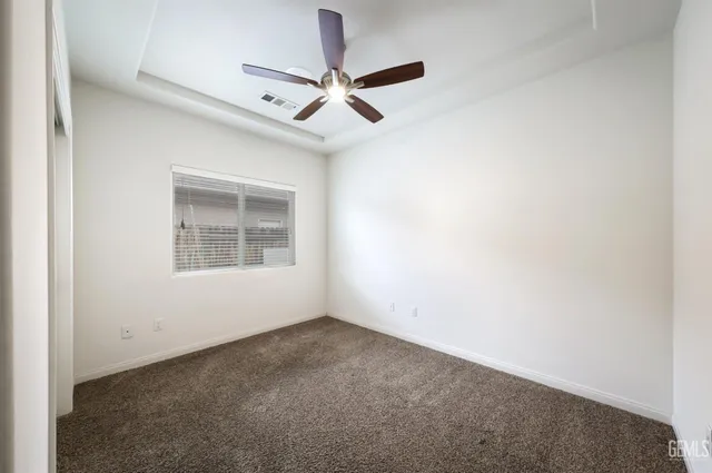 an empty room with a window and a fan