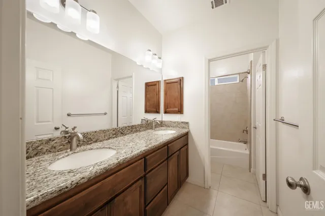 a bathroom with a granite countertop sink and a mirror