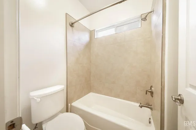 a white toilet sitting next to a bath tub