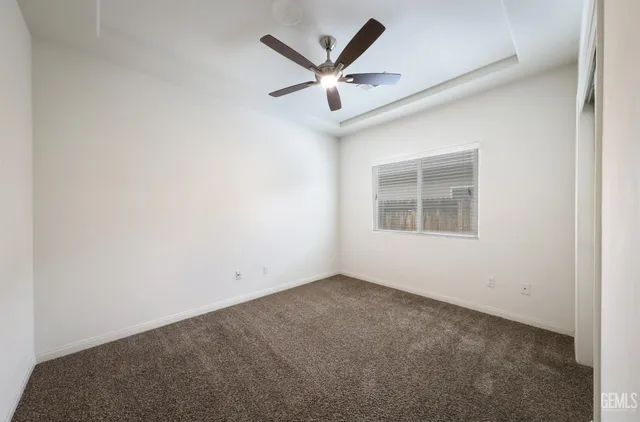 an empty room with closet and ceiling fan