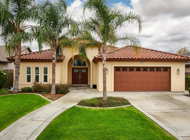 a front view of a house with a garden and yard