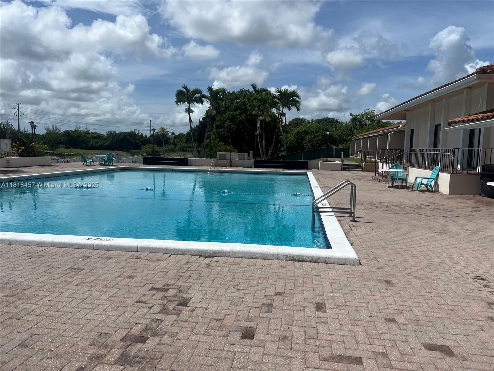 4156 Inverrary Drive, Unit 309 Lauderhill, FL 33319 - Photo 11 of 16 a view of swimming pool that has lawn chairs with plants and trees