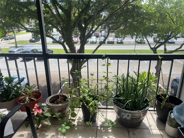 a view of a balcony with chairs and potted plants
