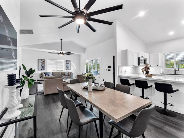 a kitchen with a dining table chairs and white cabinets