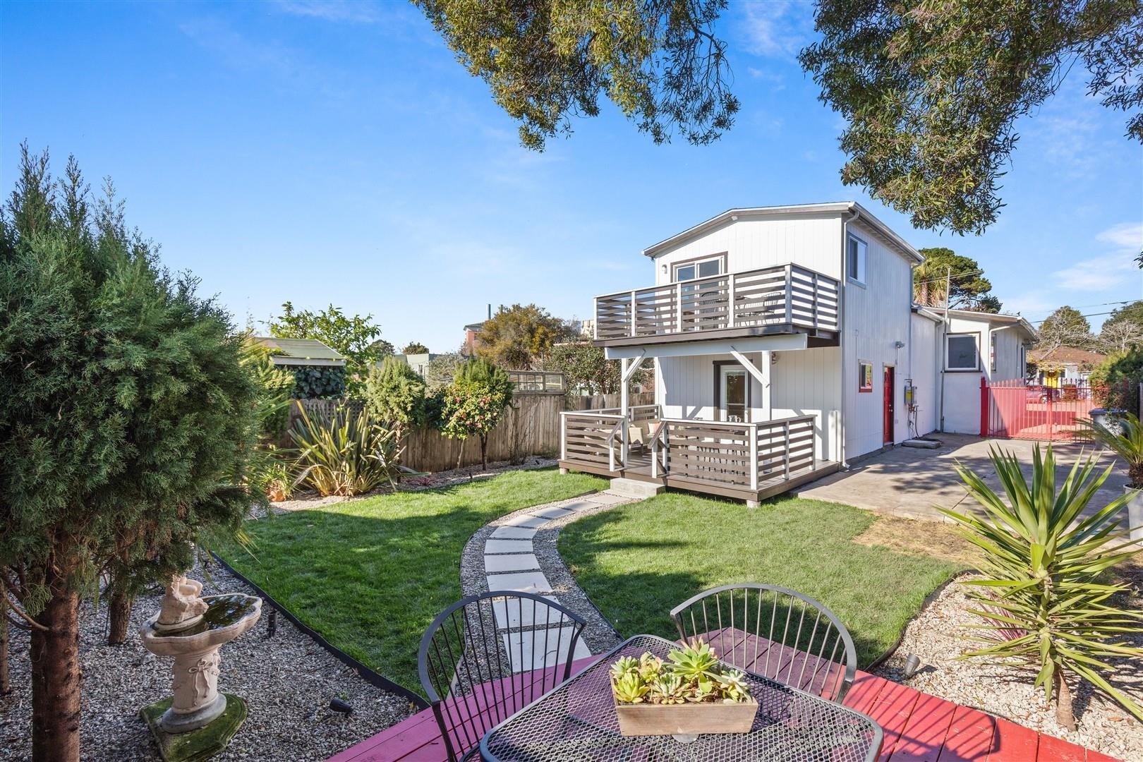 Rear view of house featuring a fenced backyard, a patio, and a deck