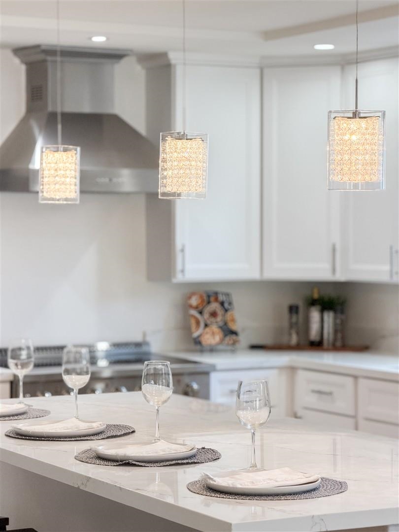 1524 Blake Street Berkeley, CA 94703 - Photo 33 of 59 Kitchen with wall chimney range hood, white cabinets, and light stone countertops