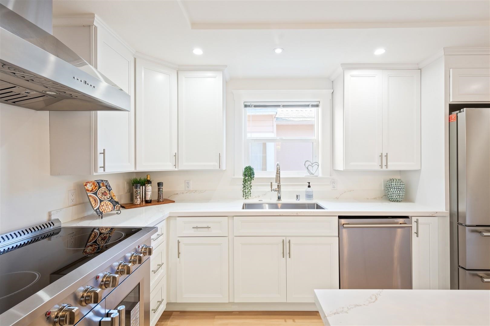 1524 Blake Street Berkeley, CA 94703 - Photo 34 of 59 Kitchen with stainless steel appliances, wall chimney range hood, white cabinetry, and recessed lighting