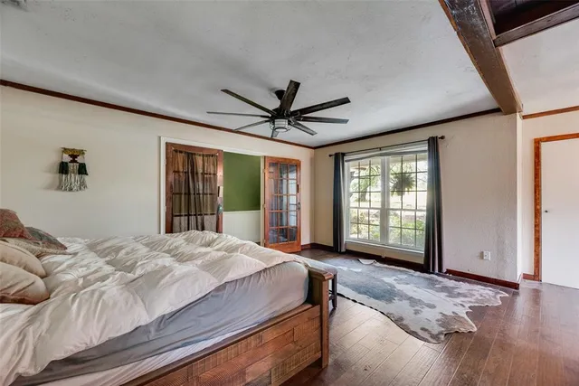 a bedroom with a large bed and windows
