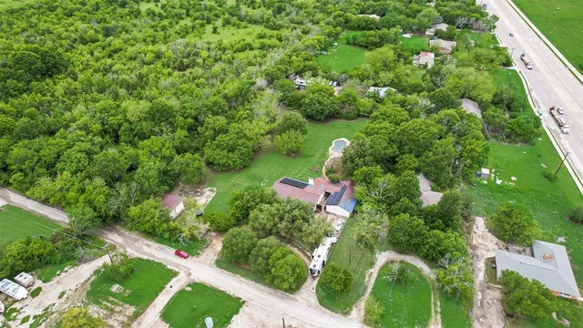 an aerial view of residential house with outdoor space and trees all around