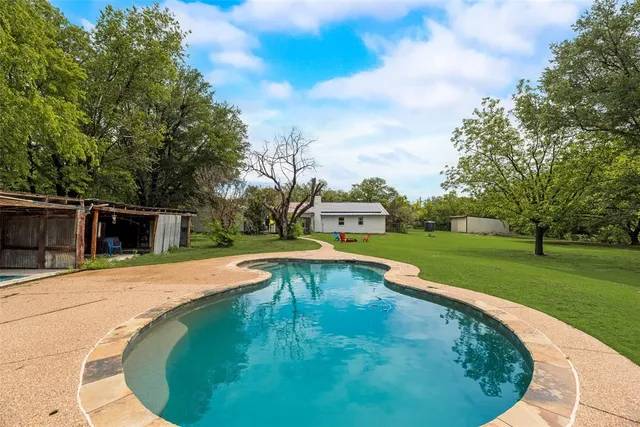 a swimming pool with outdoor seating and garden