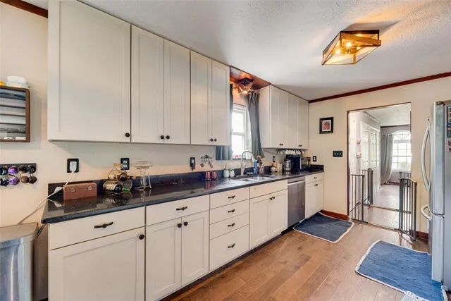 a kitchen with granite countertop white cabinets and white appliances
