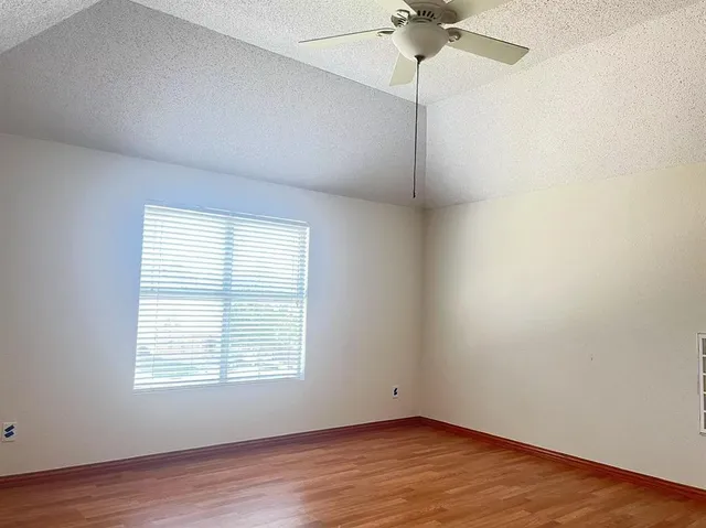 an empty room with a window and a fan