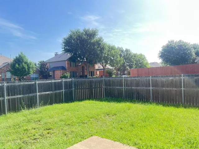 a view of a backyard with a swing and plants