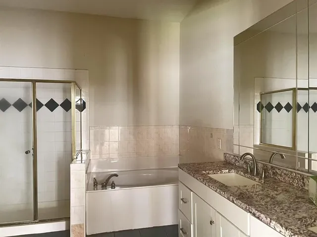 a bathroom with a granite countertop sink and a mirror