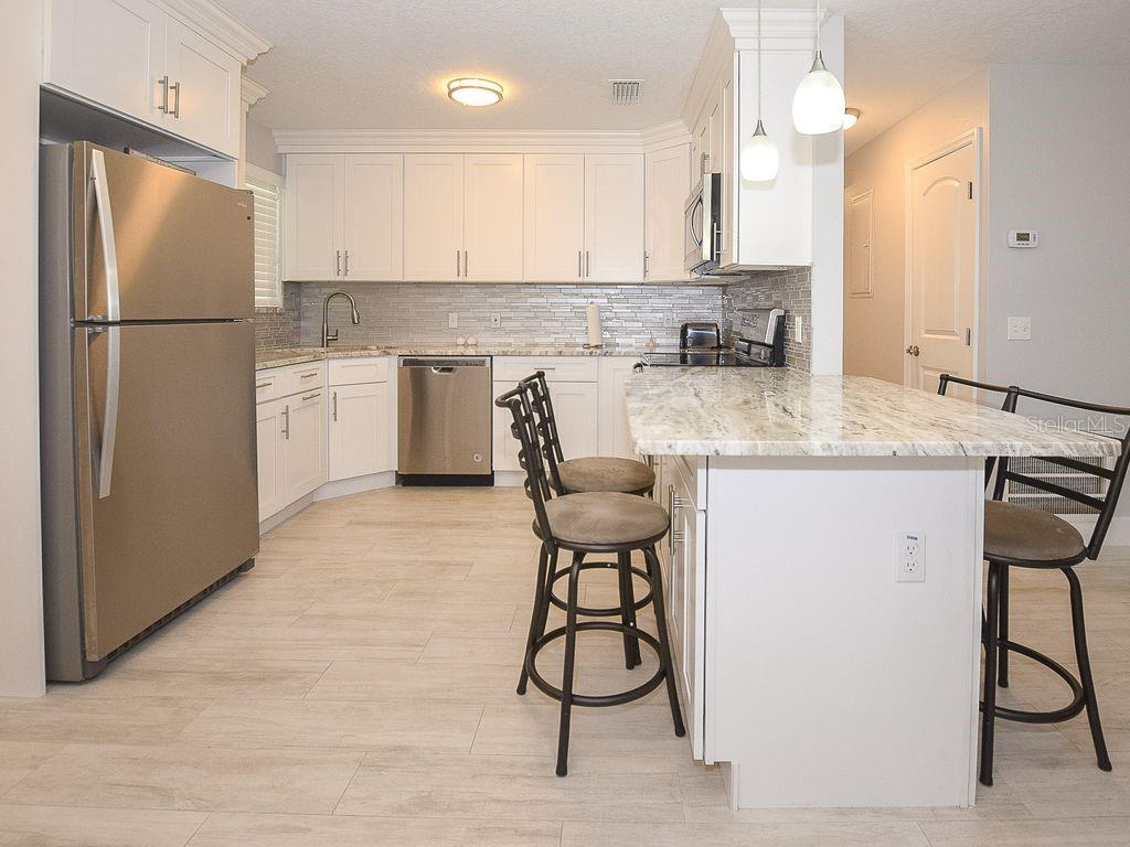 159 Holland Road Ormond Beach, FL 32176 - Photo 11 of 55 a kitchen with stainless steel appliances granite countertop a refrigerator and a stove top oven